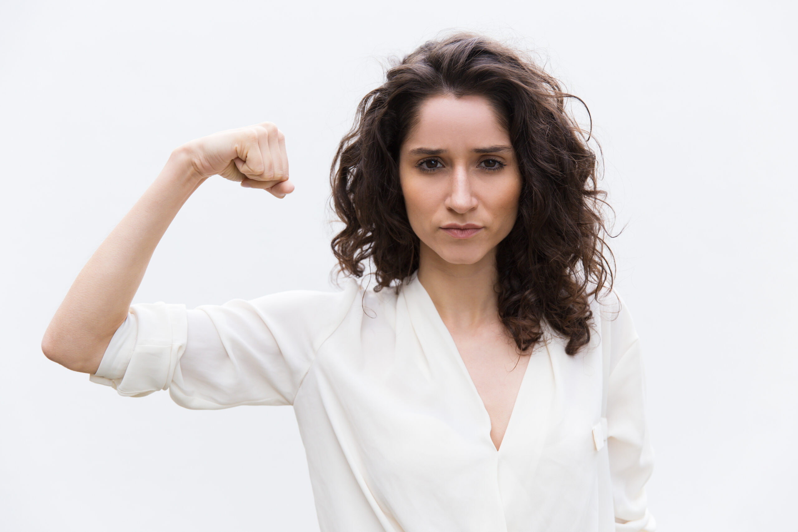 Confident serious woman flexing bicep
